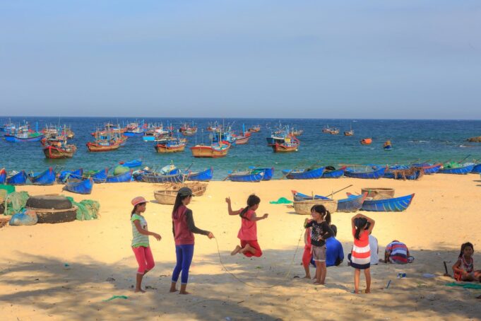 Børn der leger på stranden i Vietnam