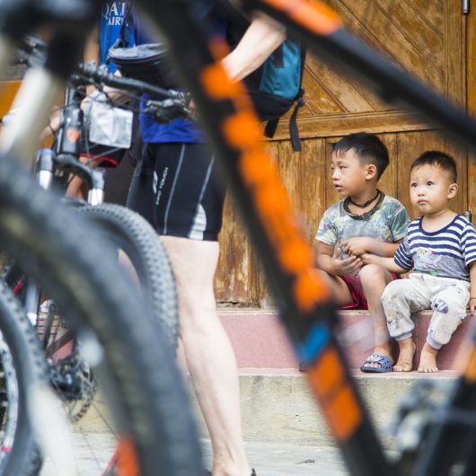 Børn med cykel i forgrunden