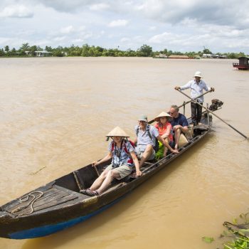 Happy tourists relaxing on a Mekong delta river tour
