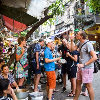 Turist gruppe prøver eksotisk streetfood i Hanois gader