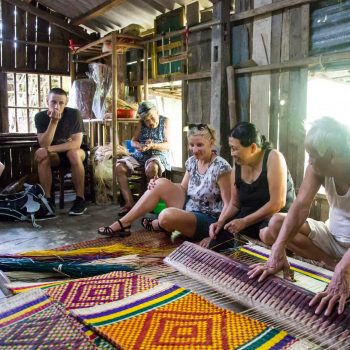 Turists learning local handicraft from Vietnamese in Hoi An