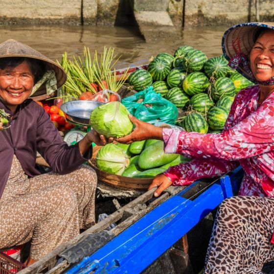 Vietnamese-woman-selling-fruits-on-floating-market-Mekong-River-Delta-Vietnam