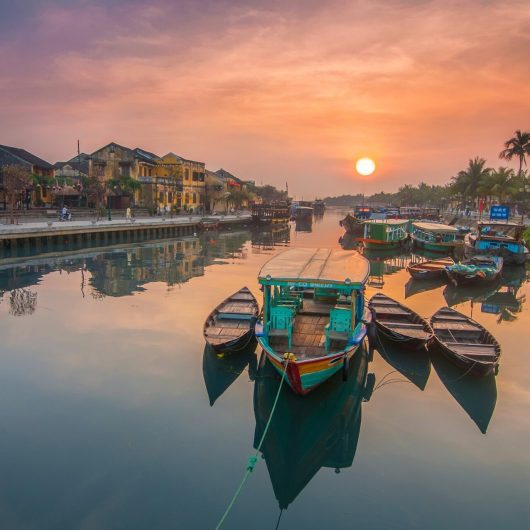 Solnedgang over flod i Hoi An